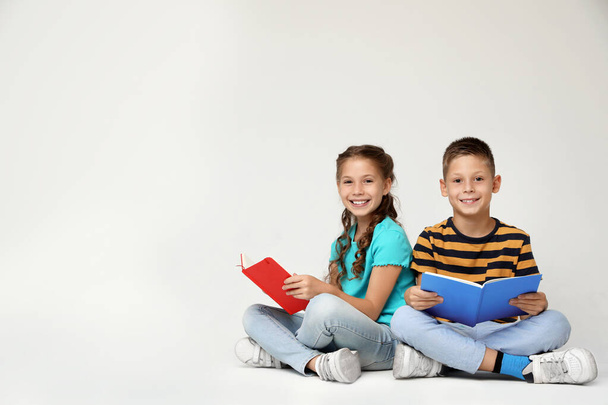 Petits enfants lisant des livres sur fond gris. Espace pour le texte
 - Photo, image