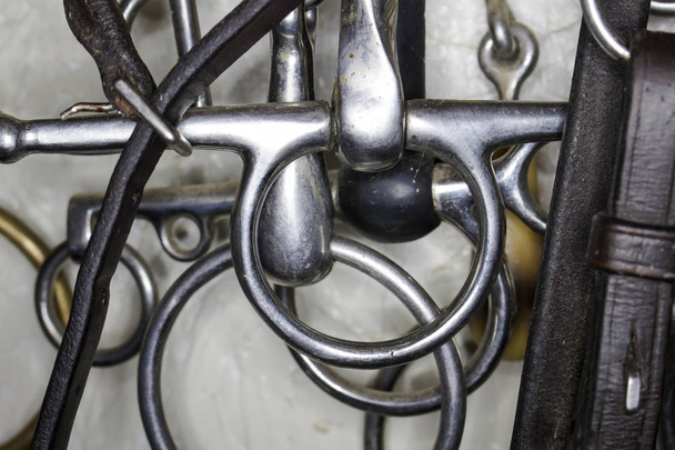 Trenchle tuercas de metal con asas largas, anillos y correas de cuero de cerca
 - Foto, imagen