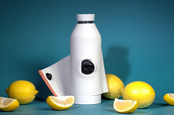 Reusable bottle with refreshing diet water with lemon on a bright blue background. Top view, copy space. The concept of detox drink, lemonade, rejection of plastic - Photo, Image