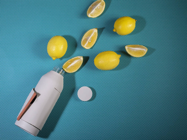 Reusable bottle with refreshing diet water with lemon on a bright blue background. Top view, copy space. The concept of detox drink, lemonade, rejection of plastic - Photo, image