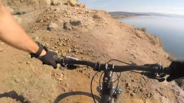 Man riding enduro mountain bike on rocky trail at the seaside in Croatia. View from first person perspective POV. Gimbal stabilized video. Shot with GOPRO HERO4 2.7K. - Felvétel, videó