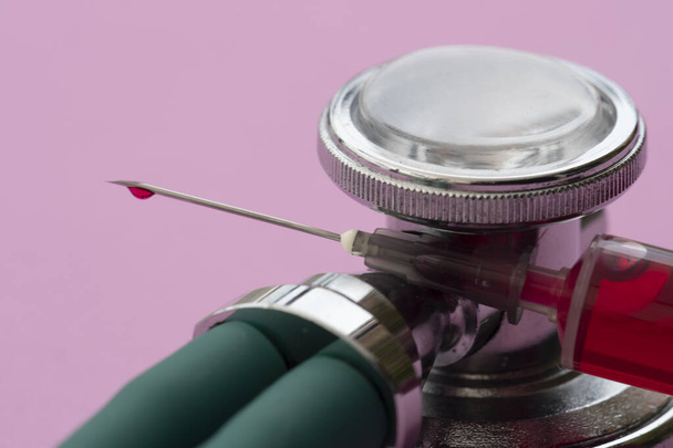 stetoskop z rurką próżniową pełną krwi na liliowym tle - Zdjęcie, obraz