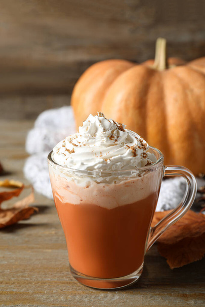 Pumpkin spice latte with whipped cream in glass cup on wooden table - Fotografie, Obrázek