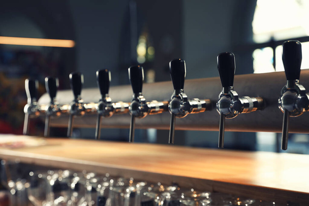 Row of shiny beer taps in pub - Foto, Bild