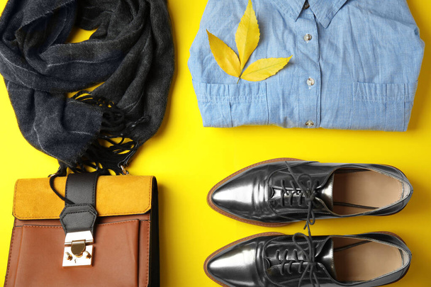 Flat lay composition with warm clothes and autumn leaves on yellow background - Foto, Imagem