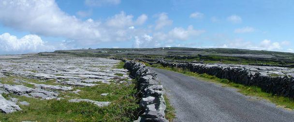 Panorâmica das paredes de pedra e da faixa de rodagem na Ilha de Inishmore, Irlanda
 - Foto, Imagem