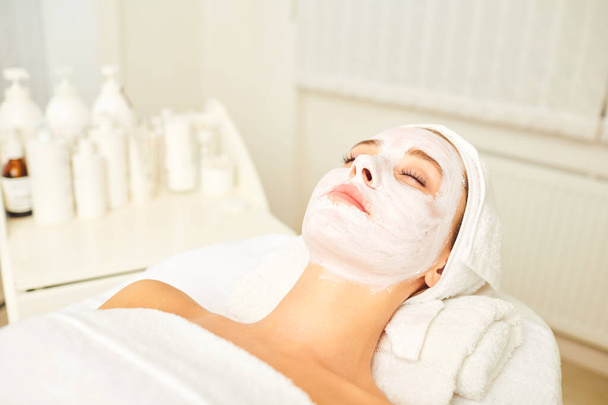 Facial skin treatment with a cosmetic mask in a beauty salon. - Φωτογραφία, εικόνα