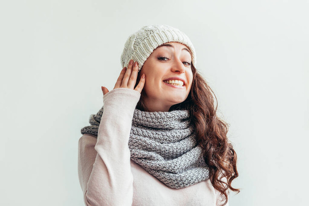 Смеющаяся девушка в теплой одежде шляпа и шарф на белом фоне
 - Фото, изображение