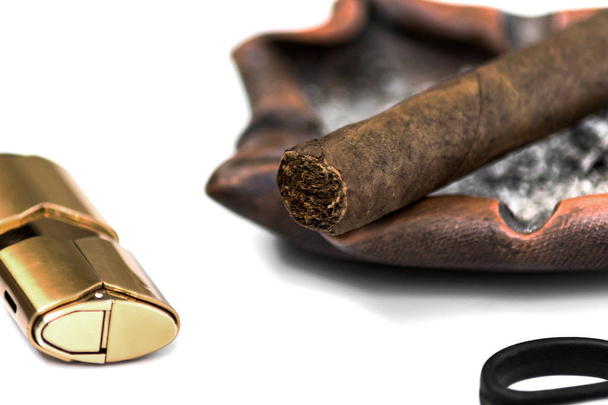 Nahaufnahme einer Zigarre, Feuerzeug, Aschenbecher und Fragment einer Guillotine auf weißem Hintergrund - Foto, Bild