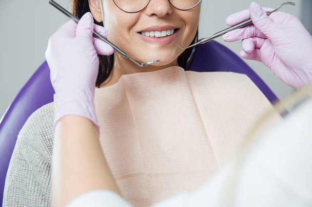 Una mujer se está preparando para un examen dental. Mujer con dientes examinados en dentistas
.  - Foto, Imagen