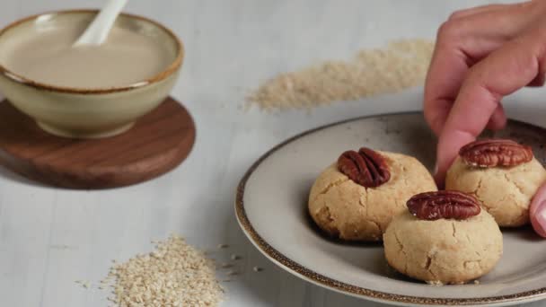 Female hand takes tahini cookies. Oriental sweets. - Video, Çekim