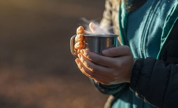vrouw holding cup met warme drank outdoor - Foto, afbeelding