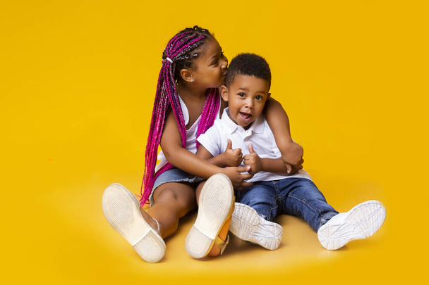 Adorable african american siblings sitting on floor and cuddling - Valokuva, kuva