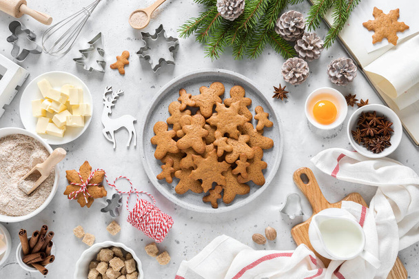 Christmas or X-mas baking culinary background, cooking recipe. Xmas, Noel gingerbread cookies on kitchen table and ingredients for festive baking. New Year holiday decorations with fir tree - Fotó, kép