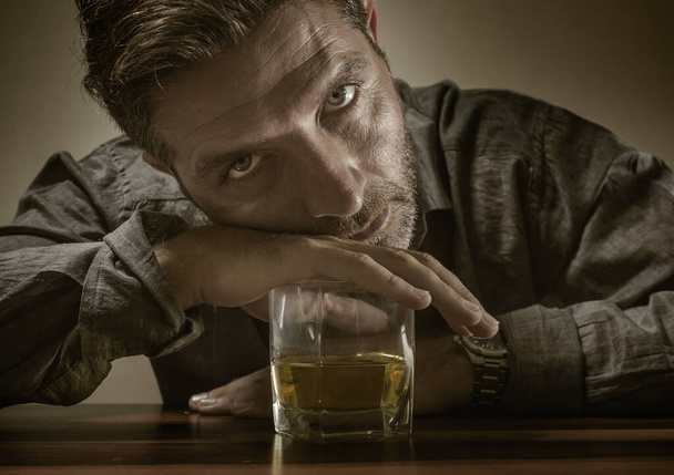 desperate alcoholic man . depressed addict isolated in front of whiskey glass trying not drinking in dramatic expression suffering alcoholism and alcohol addiction problem - Фото, изображение