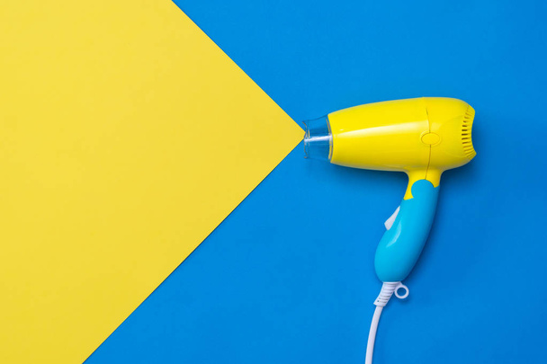 Simulación del flujo de aire de azul a amarillo secador de pelo amarillo sobre un fondo azul
. - Foto, imagen