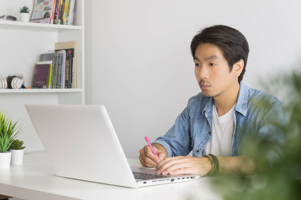Asian Casual Businessman lub Freelancer Praca z laptopem i notatką w Ministerstwie Spraw Wewnętrznych - Zdjęcie, obraz