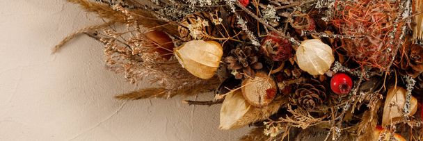 Christmas wreath, composition of decorations and dried flowers on a textured background. Abstract composition, idea, decor. Holiday concept.Banner. - Foto, immagini