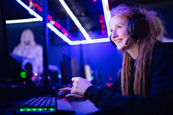 Streamer красива дівчина посміхається професійний геймер, граючи в онлайн ігри комп'ютер, неоновий колір
 - Фото, зображення