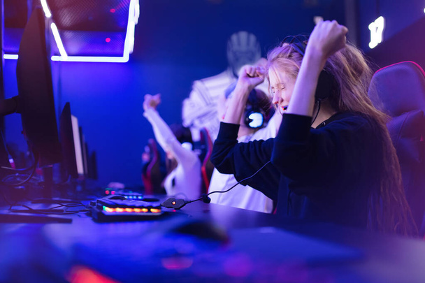 Streamer kaunis tyttö ammatillinen gamer voittaja iloitsee voiton pelaa online-pelejä tietokone kuulokkeet
 - Valokuva, kuva