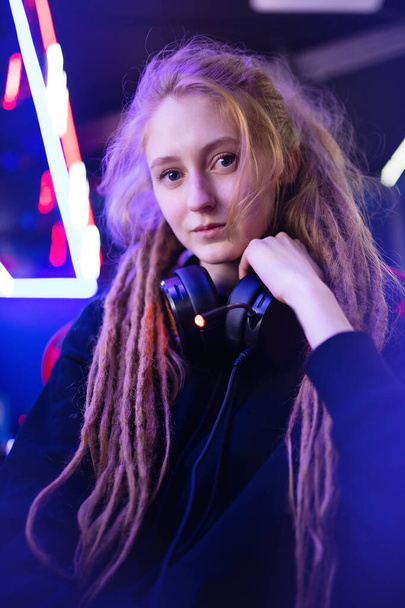 Streamer güzel kız profesyonel oyuncu gülümsemesi çevrimiçi oyunlar oynuyor kulaklıkla bilgisayar, neon rengi - Fotoğraf, Görsel