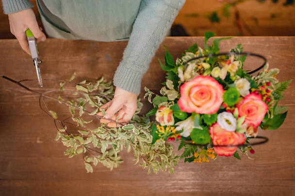 Blumenmädchen sammelt Rosensträuße, schneidet Blätter mit Gartenschere, Draufsicht - Foto, Bild