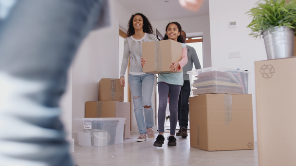 Excited family carrying boxes into new home on moving in day - shot in slow motion - Filmmaterial, Video
