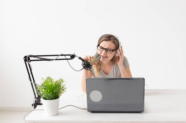 Radio, DJ, blogging and people concept - Smiling woman sitting in front of microphone, host at radio - 写真・画像