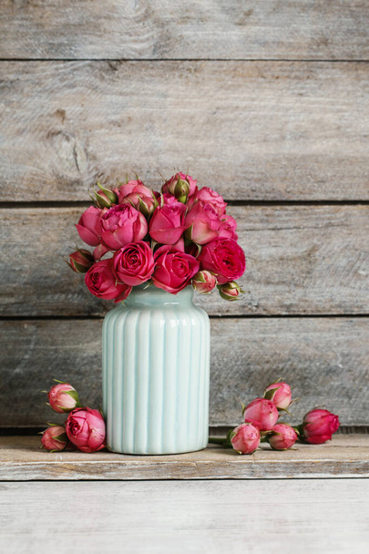 Bukiet różowych róż w niebieskim wazonie ceramicznym. Motyw z pocztówki.  - Zdjęcie, obraz