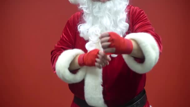 Santa Claus Fighter kickbox With Red Bandages against the background of a red wall. - Filmagem, Vídeo