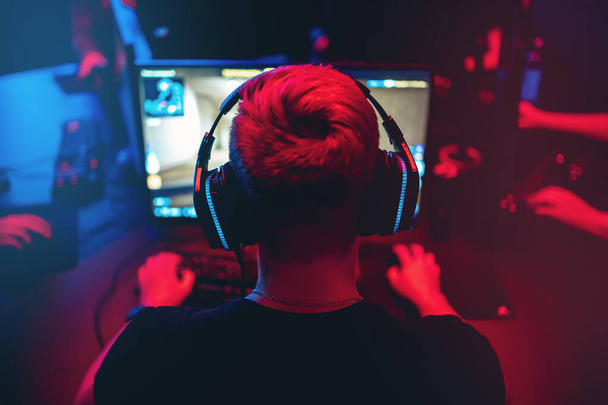 Professzionális játékos játék online játékok versenyek pc számítógép fejhallgató, homályos piros és kék háttér - Fotó, kép