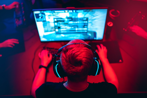 Professional cyber gamer studio room with personal computer armchair, keyboard for stream in neon color blur background. Soft focus - Photo, Image