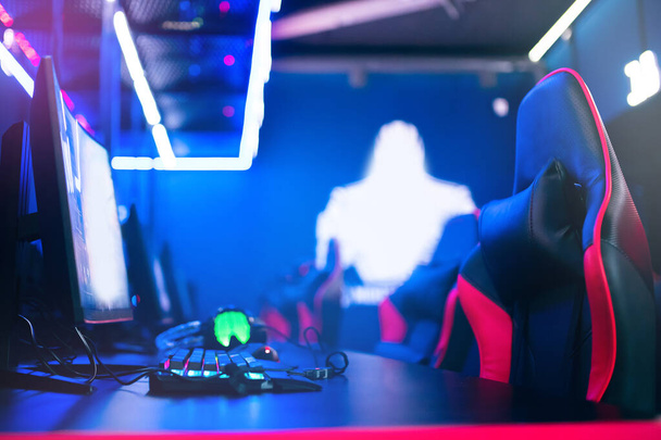 professionelle Cyber-Gamer-Studioraum mit PC-Sessel, Tastatur für Stream in Neon-Farbe verschwimmen Hintergrund. Weicher Fokus - Foto, Bild