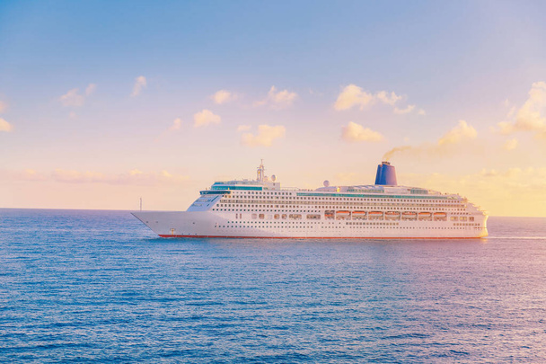 Luksusowy statek wycieczkowy opuszcza port zachód słońca w błękitnym morzu z chmurami - Zdjęcie, obraz