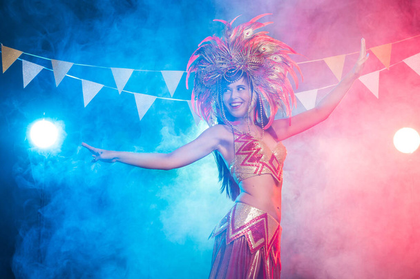 Koncept kabaret, tanečnice a dovolené-rozkošná mladá dívka v zářivě barevném karnevalu na tmavém pozadí - Fotografie, Obrázek