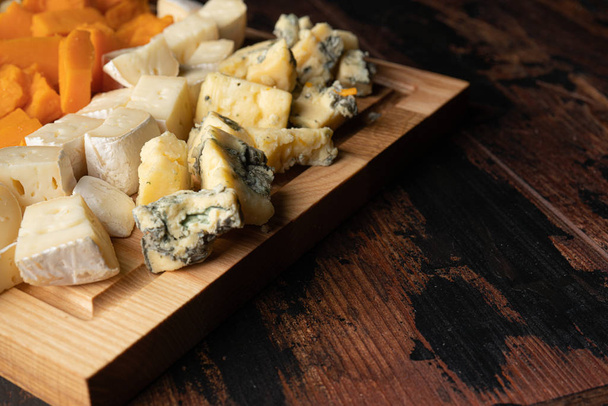various cheeses with honey on the wooden board - Фото, изображение