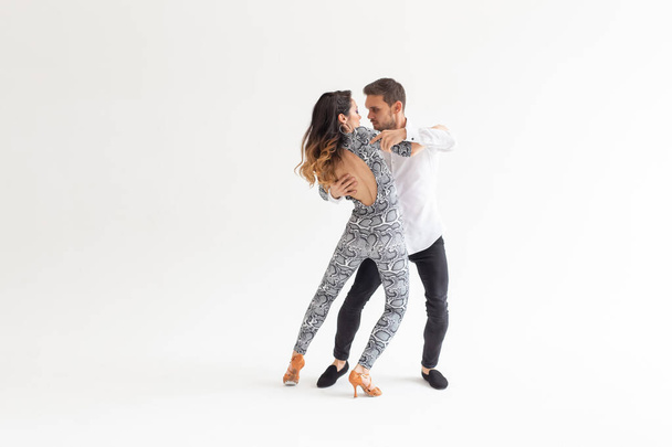 Taitavat tanssijat esiintyvät valkoisella taustalla kopiointitilalla. Aistillinen pari suorittaa taiteellinen ja emotionaalinen nykytanssi
 - Valokuva, kuva