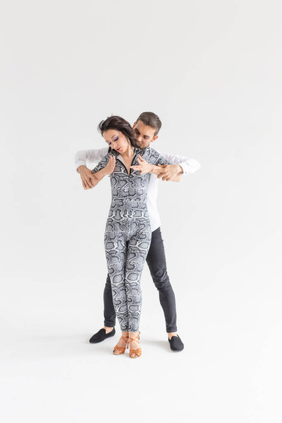 Jeune couple dansant danse latine bachata, merengue, salsa, kizomba. Deux pose d'élégance sur fond blanc avec espace de copie
 - Photo, image