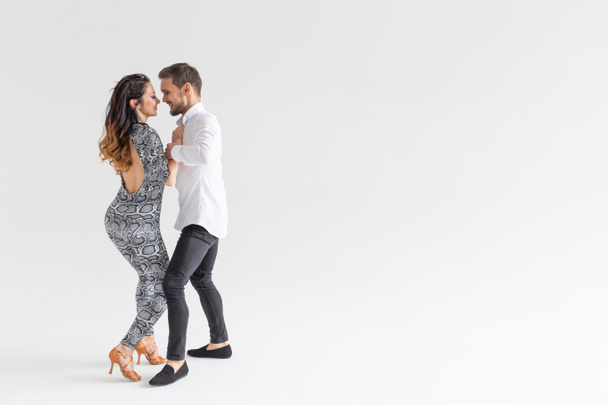 Молодая пара любит танцевать социальный данс кизомба или бачата на белом фоне с копировальным пространством
 - Фото, изображение