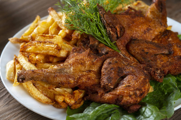 roasted chicken and french fries on a wooden table - Photo, Image