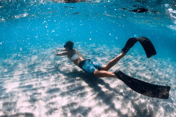 Freediver glisse sous l'eau sur fond sablonneux. Nager avec la nageoire
 - Photo, image