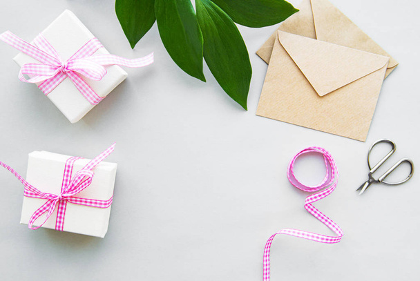 Coffrets cadeaux, enveloppe et feuilles vertes sur fond blanc
 - Photo, image