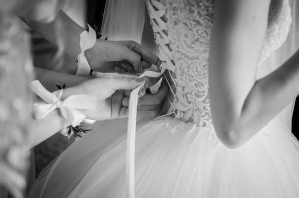 Dama de honra ajudar noiva a usar vestido de noiva preto e branco
 - Foto, Imagem