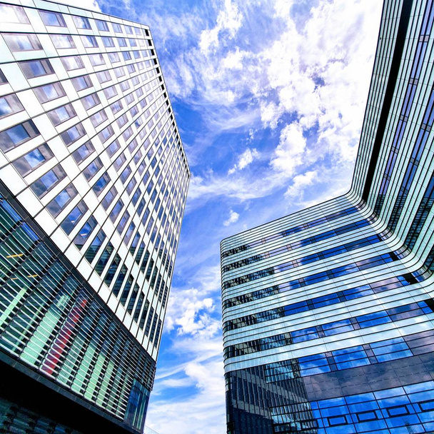 Dois edifícios modernos entre o céu azul com cores brancas
 - Foto, Imagem