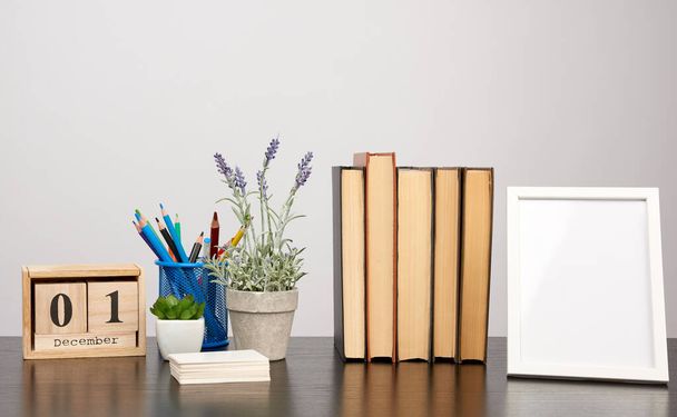 empty white photo frame, stack of books and a pot of growing lav - Photo, Image