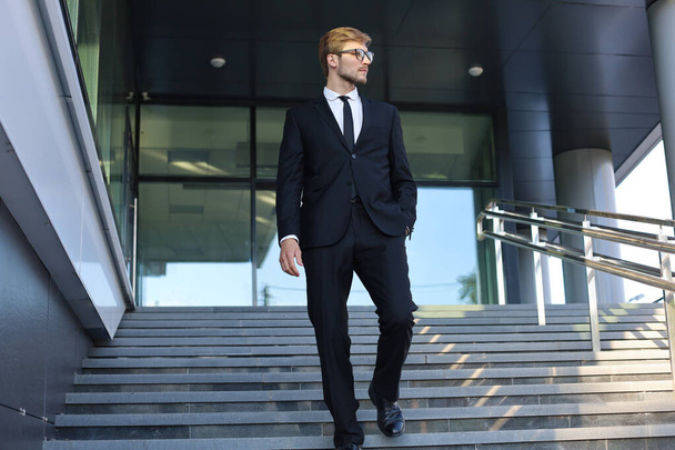 Successful young businessman walking down the stairs outside the office building. - Fotografie, Obrázek
