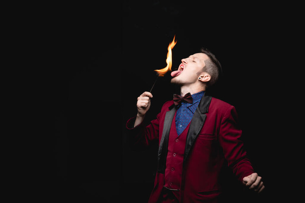 Tűz show, fakir bűvész lenyeli éget, és kinyújtja a nyelvét a szájába - Fotó, kép