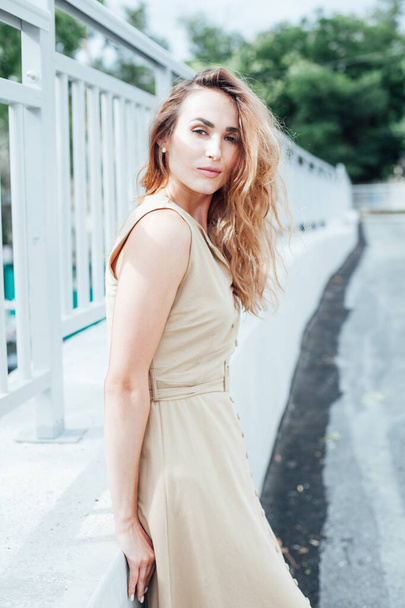 hermosa mujer de moda en un vestido beige en el parque en un paseo
 - Foto, imagen