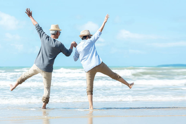 Ασιατικό lifestyle ηλικιωμένο ζευγάρι άλμα στην παραλία ευτυχισμένη στην αγάπη ρομαντική και να χαλαρώσετε χρόνο. Τουρισμός ηλικιωμένοι οικογένεια ταξίδια αναψυχή και δραστηριότητα μετά τη συνταξιοδότηση στις διακοπές και το καλοκαίρι. - Φωτογραφία, εικόνα