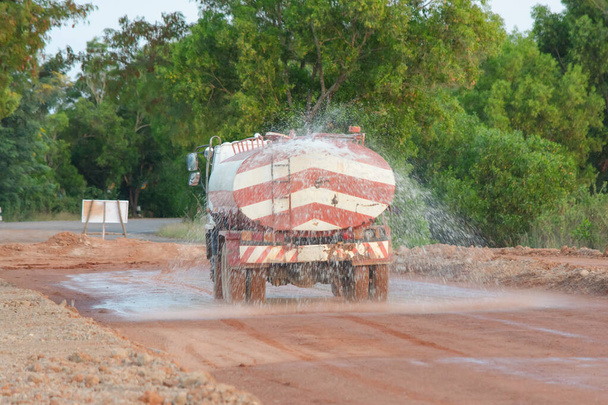 A vízszállító kamion vizet permetez egy új útépítési helyszínhez. - Fotó, kép